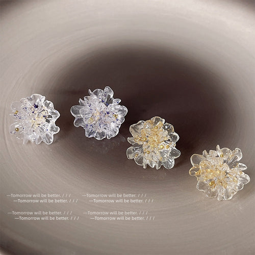 Several clear resin flowers showing foil and flecks