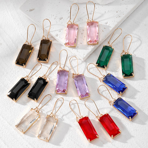 Assorted rectangle faceted glass dangle earrings in eight colors on white stone