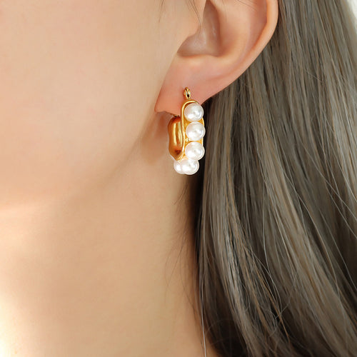 Side profile gold U-shape earring with white pearls on ear