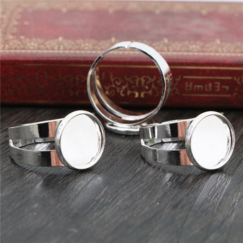 Grouped detail view of silver-tone adjustable ring blanks with smooth round bezel pads