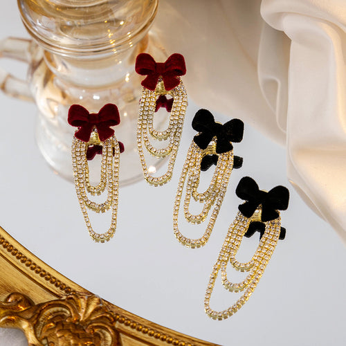 Burgundy and black velvet bow rhinestone drop earrings on mirror