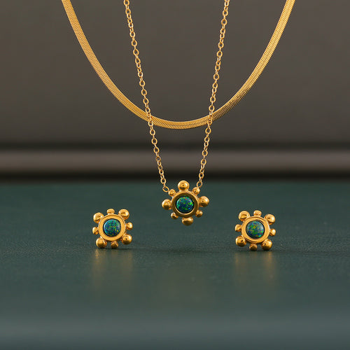 Sunflower necklace studs and herringbone chain on dark surface