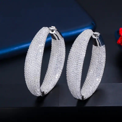 Silver thick full pave hoop earrings pair upright on dark surface