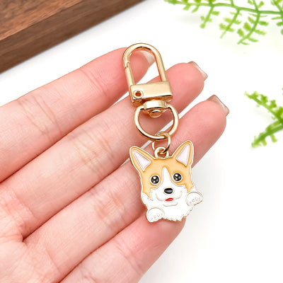 Image 1 showing a hand holding a keychain with a small dog on it.