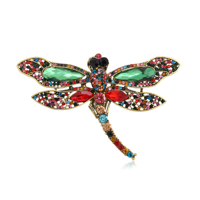 Front view of the colorful crystal dragonfly brooch with long curved tail on a white background
