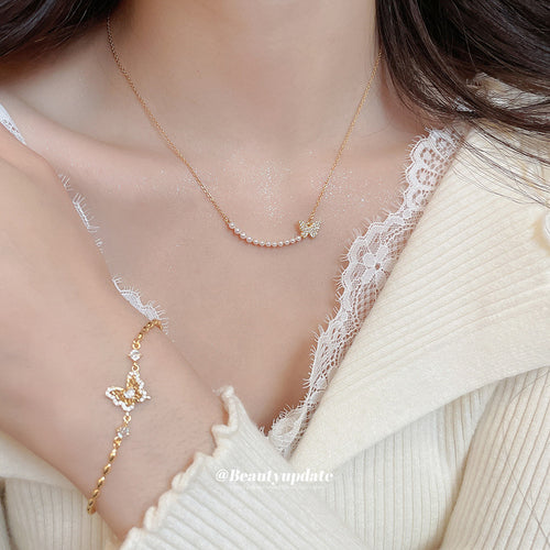 Gold pearl butterfly necklace and gold butterfly bracelet worn together