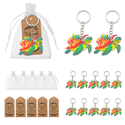 A green turtle carrying colorful packages shown with organza bags, thank-you tags, and multiple keychains.