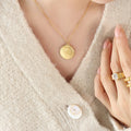 Gold Round Coin Pendant Necklace with Engraved Cherub Angel Motif view 1