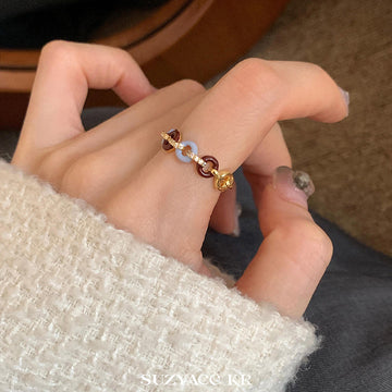 Gold Tone Burgundy And Pale Blue Interlocking Ring With Crystals