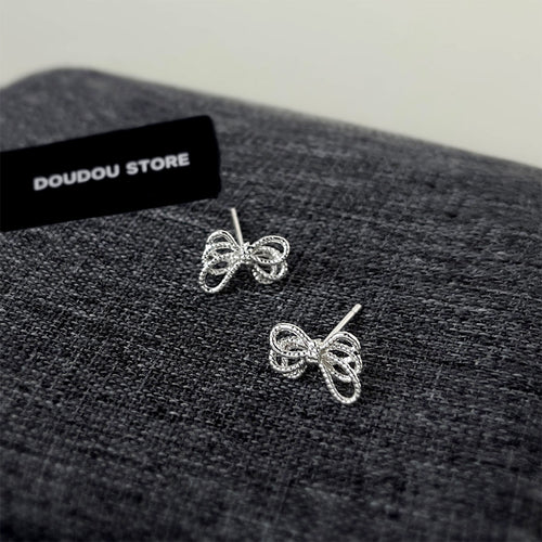 Silver rope bow studs showing posts on dark gray fabric