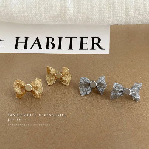 Gold and silver mesh bow studs on kraft paper with HABITER card