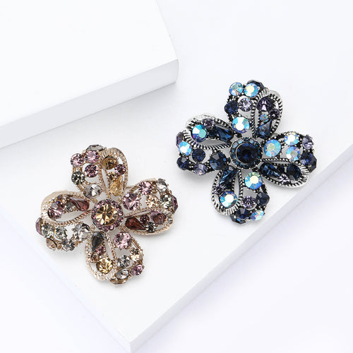 Purple and blue clover flower brooches side by side on white
