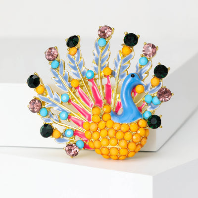 A peacock with a broad fan of colorful crystal-tipped feathers shown on a white background.