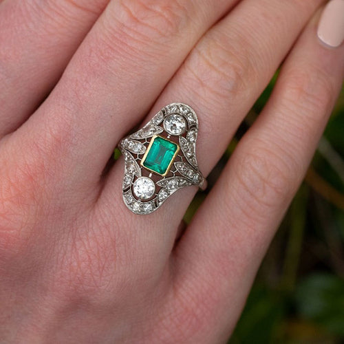 Openwork green center stone ring worn on finger outdoors