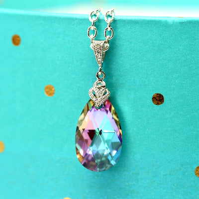 Multicolor teardrop crystal pendant on turquoise gold-dot background