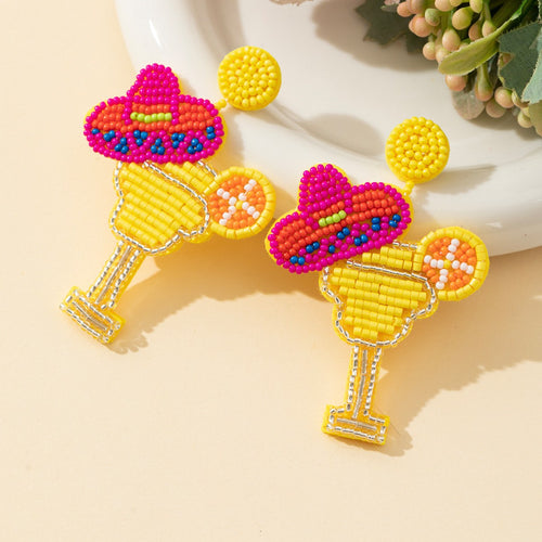 Yellow beaded margarita glass drop earrings with pink sombrero and orange slice, side view