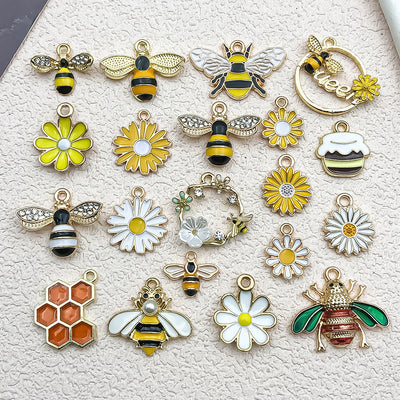 Colorful bee and daisy charms arranged on a light background