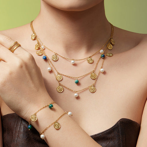 Model layered gold sun disc pearl and stone necklaces with matching bracelet
