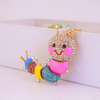 Close-up of a colorful caterpillar charm covered with clear, blue and purple rhinestones.