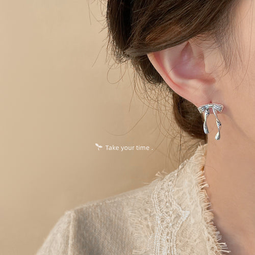 Silver long bow studs with black fabric backdrop