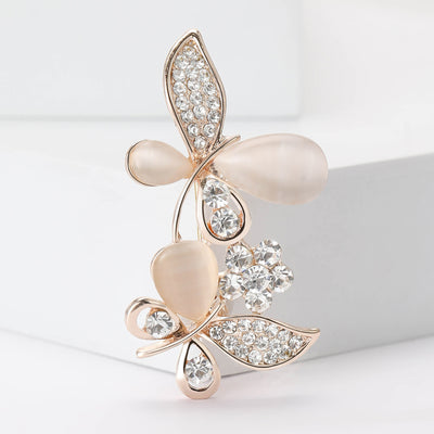 Front view of slender butterfly formed from blush petals and crystal-set leaves
