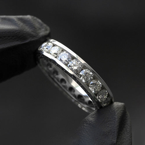 Top angle of white metal channel set round stone band ring