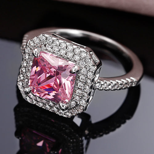 Styled view showing a pink square center, clear halo, and stone-set band