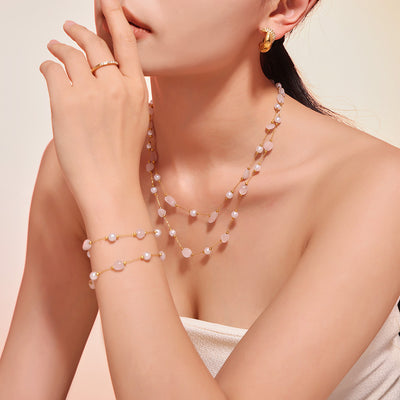 Model wearing layered pearl natural stone gold necklace and bracelet