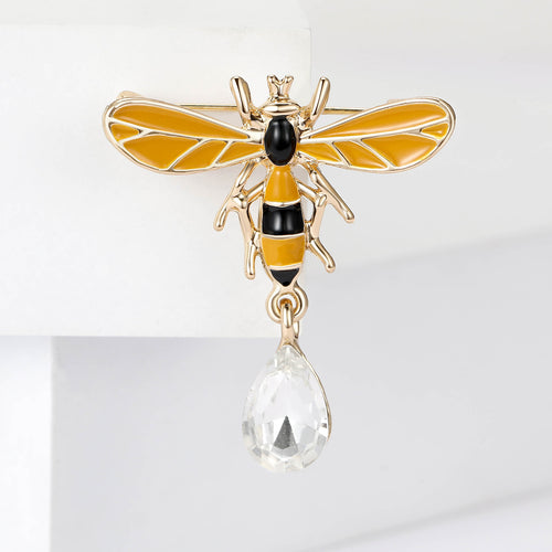 Gold enamel bee brooch with clear teardrop dangle on white