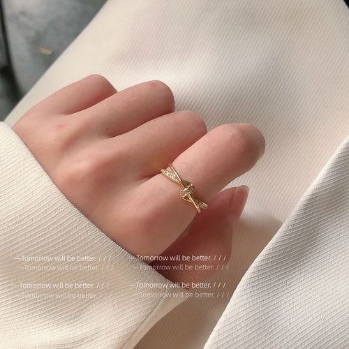 Crossed polished open rings shown worn in gold tone.