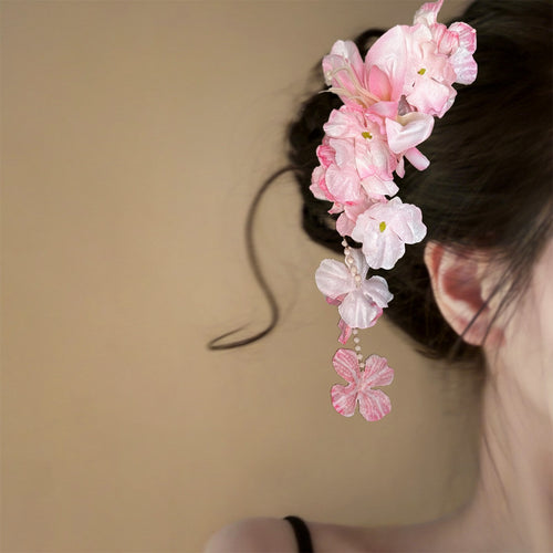 Pink fabric orchid duckbill clip worn at side of dark hair bun