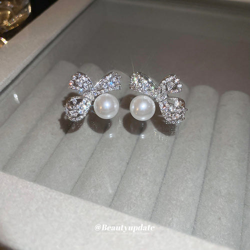 Second listing image of silver crystal bow pearl drop earrings, showing the visible finish.