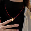 Dark Red Beaded Necklace with Gold Tone Bell Pendants view 4