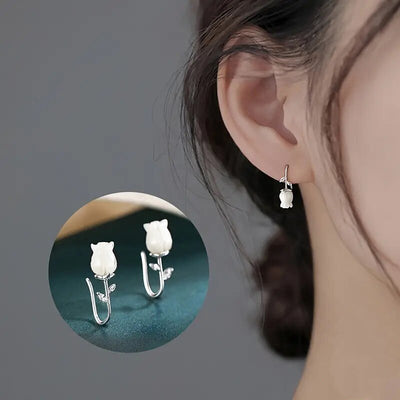 Silver white acrylic lily flower hook earring worn with inset pair