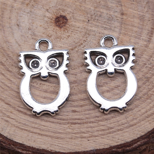 Styled close-up of the openwork owl pendant charm showing open owl body and round top loop