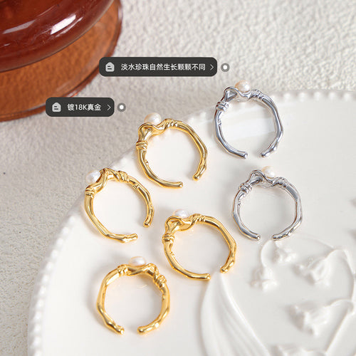 Gold and silver open pearl rings on white dish with material labels
