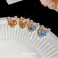 Gold Tone Crystal Heart Stud Earrings with Bow Details view 4