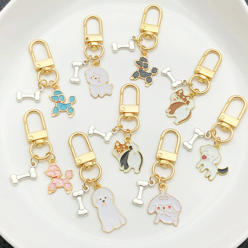 Front display of sixteen dog and bone enamel clasp keychains with visible colors and attached hardware