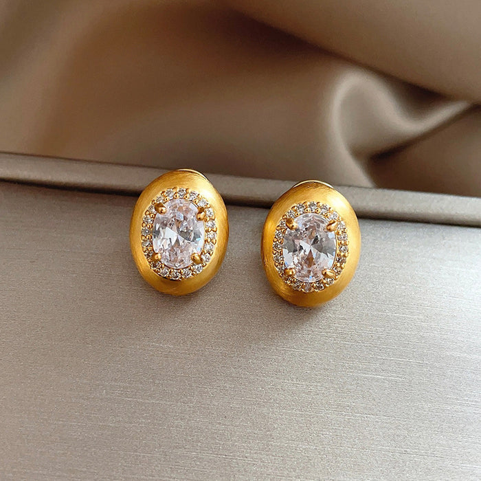 Gold Tone Brushed Oval Stud Earrings With Clear Crystal Centers