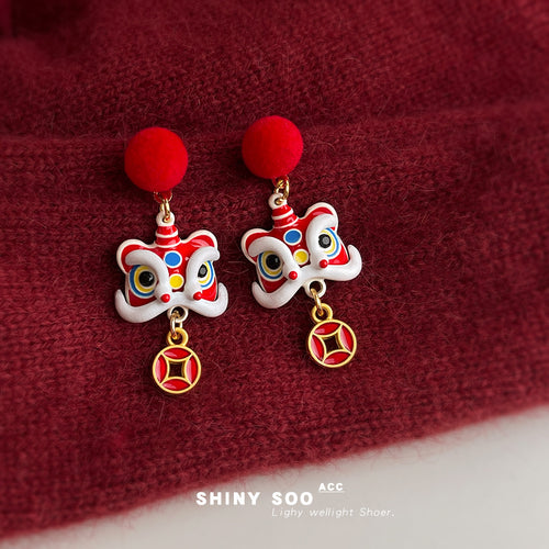 Lion dance drops with pompoms on red knit fabric