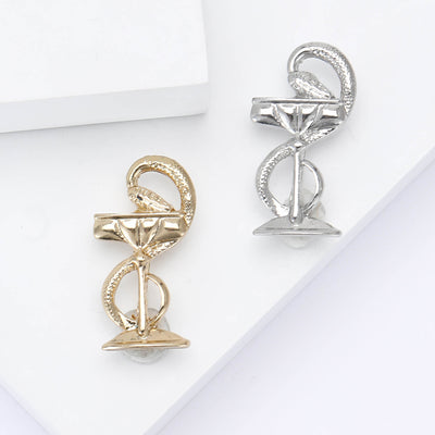 Gold and silver tone snake cocktail cup brooches on white blocks