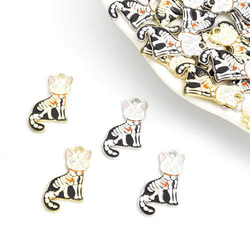 Assorted black and white skeleton cat charms arranged beside a tray on white