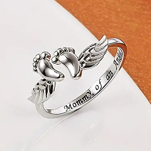 Second product view showing silver-tone engraved angel wings and baby feet open ring