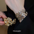 Gold Tone Wide Openwork Bracelet With Layered Textured Flowers And Leaves view 2
