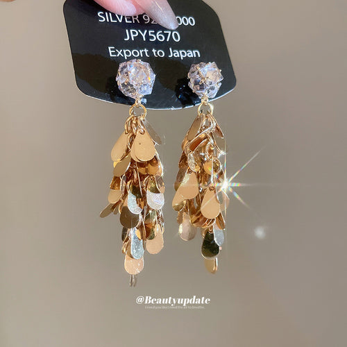 Clear crystal studs and layered gold-tone teardrop sequins shown in a front product view