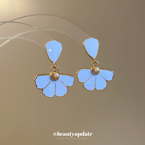 White Enamel Fan Petal Drop earrings shown in a close handheld view.