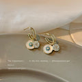 Gold Tone Blue Center Disc And Clear Flower Charm Huggie Earrings view 2