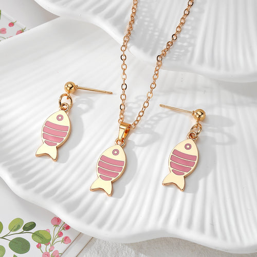 Pink enamel stripe fish earring and necklace set on white shell dish