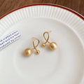 Gold Tone Polished Orb Stud Earrings with Crossing Loops view 6