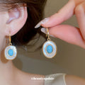 Blue Round Stone Drop Earrings with White Halo and Gold Tone Hooks view 1